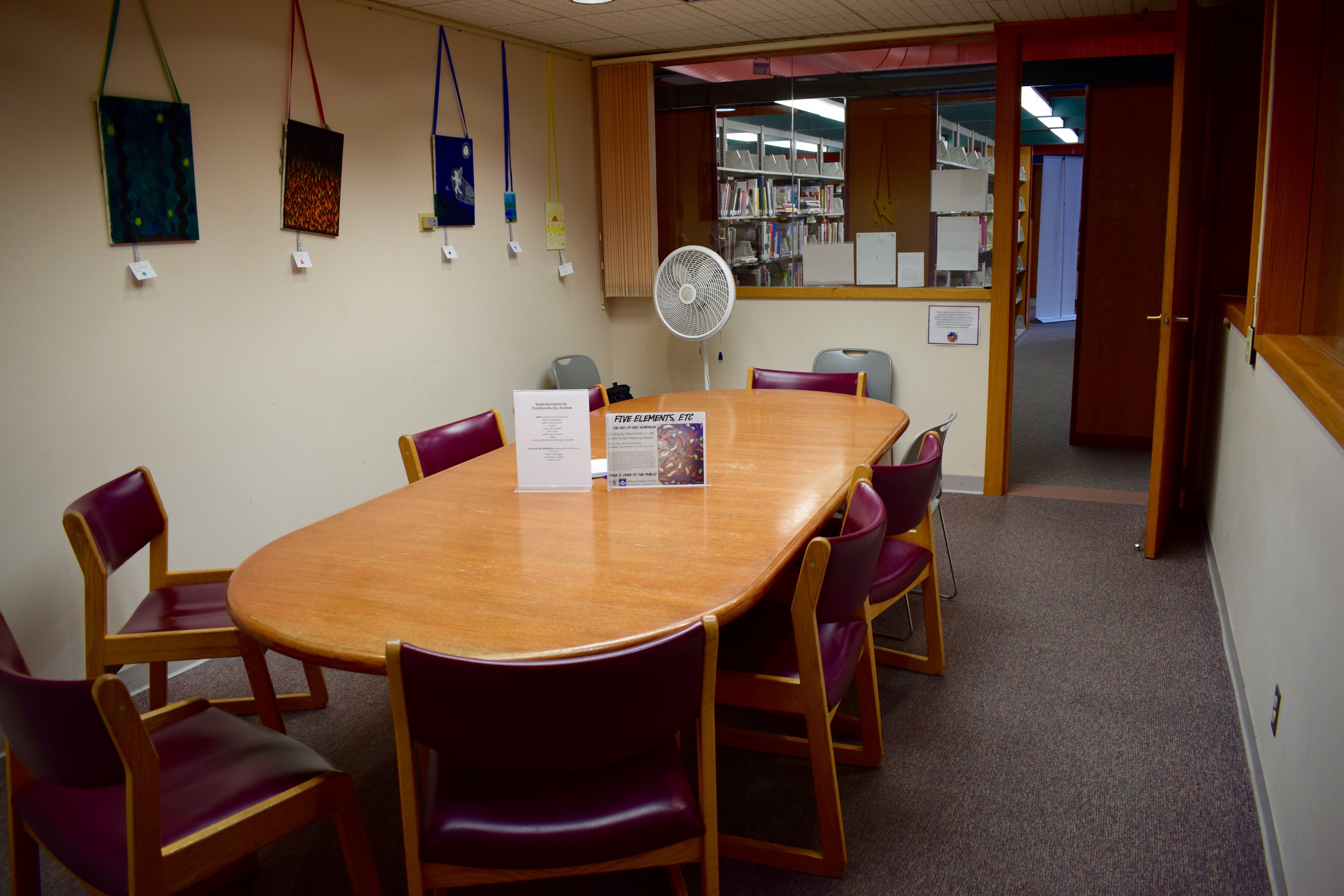 Small meeting room at the Athens Public Library, including a large oval table with chairs. 