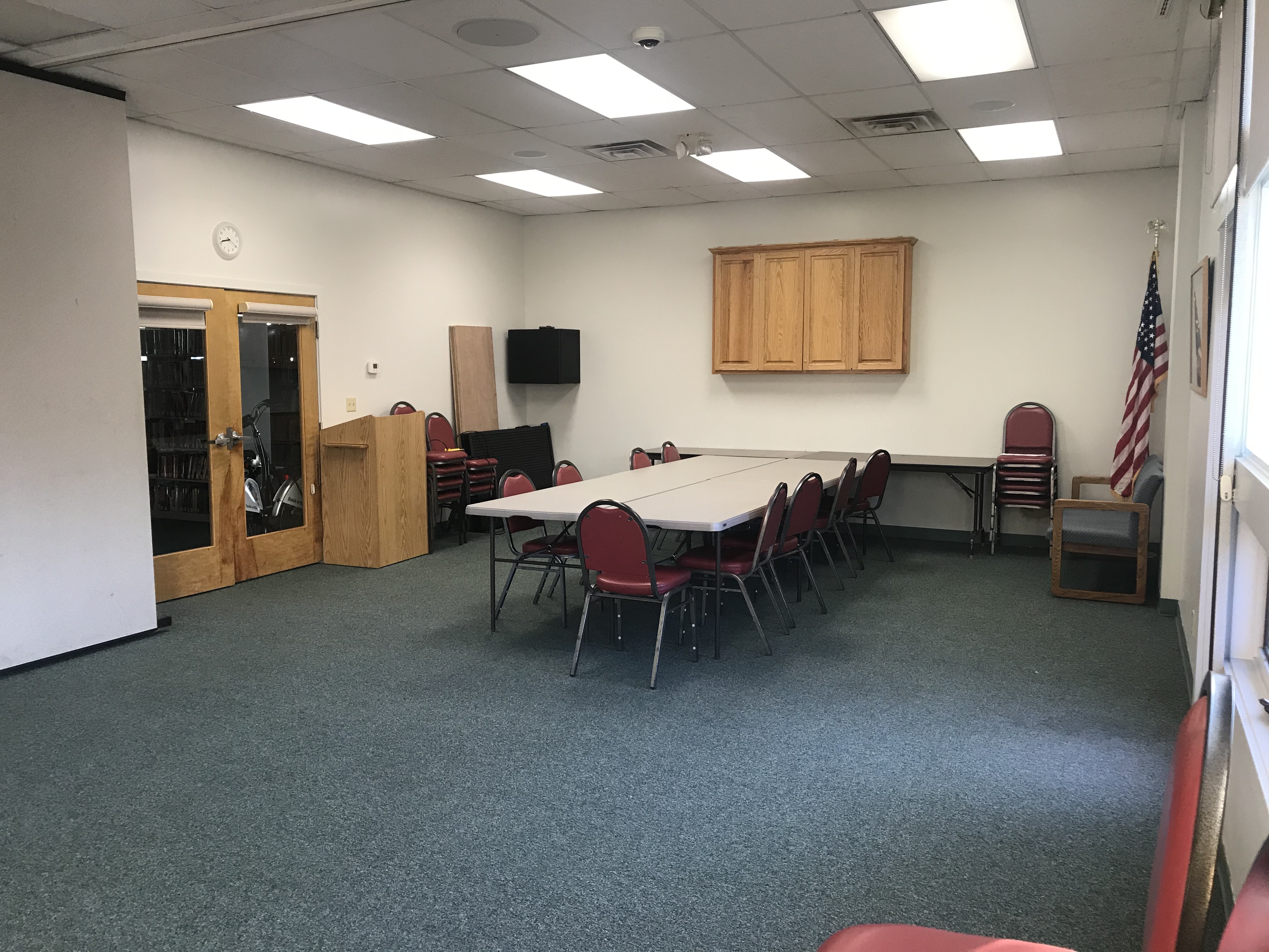The meeting room in The Plains Public Library, including presentation equipment, a table, and chairs. 