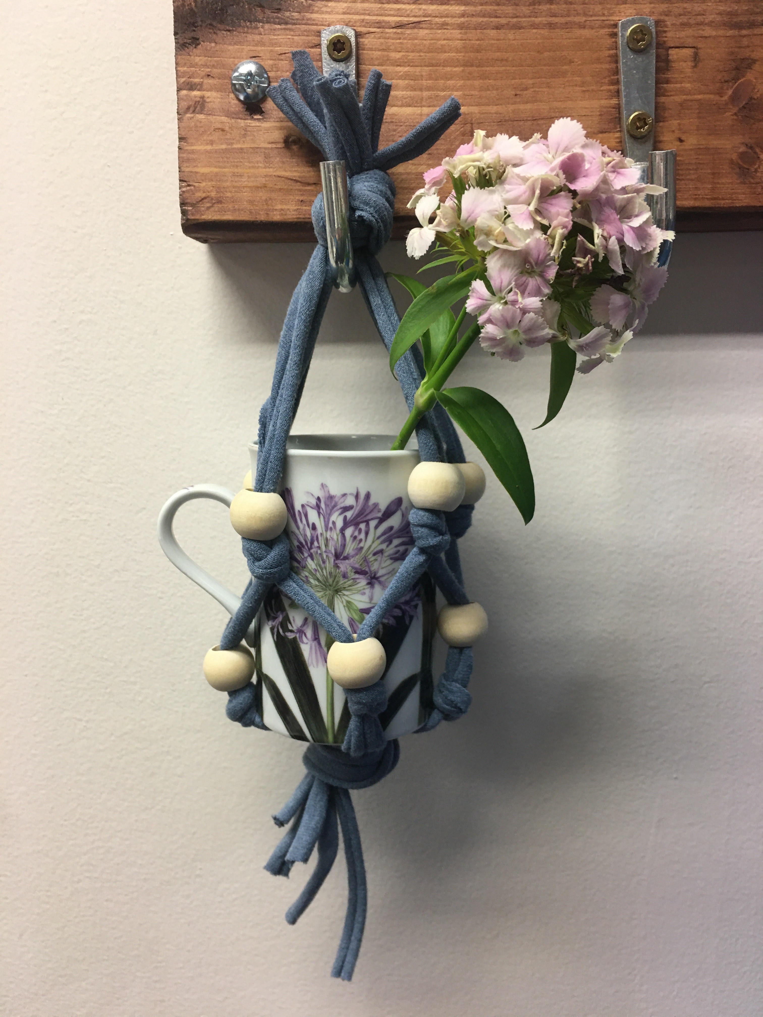 photo of a cup and flower sitting inside a t-shirt plant hanger 