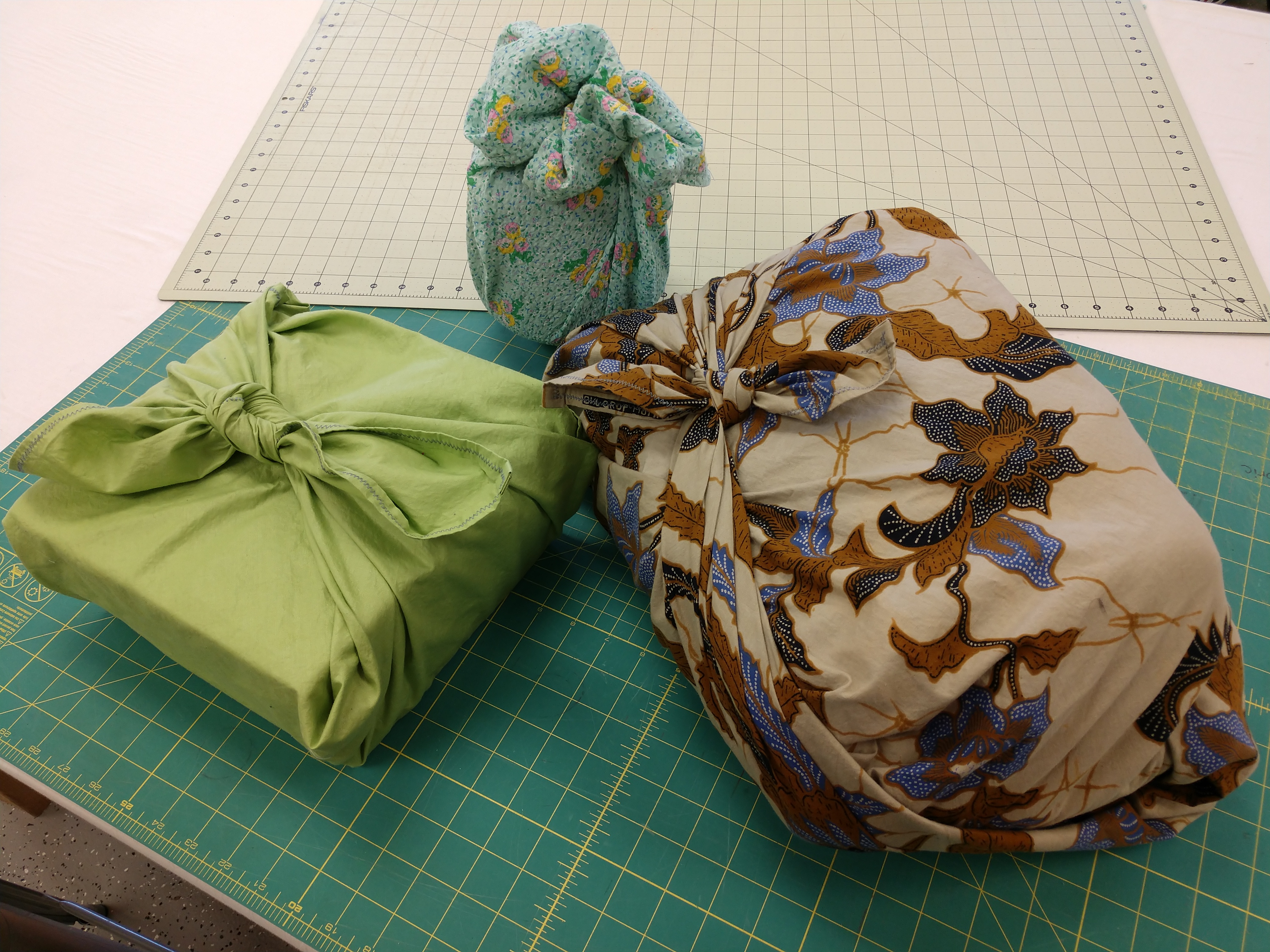 A picture of 3 gifts wrapped with fabric wrapping 'paper'
