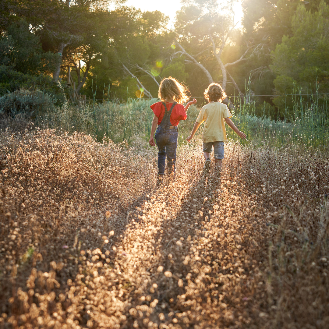 Depicts two children walking in a field