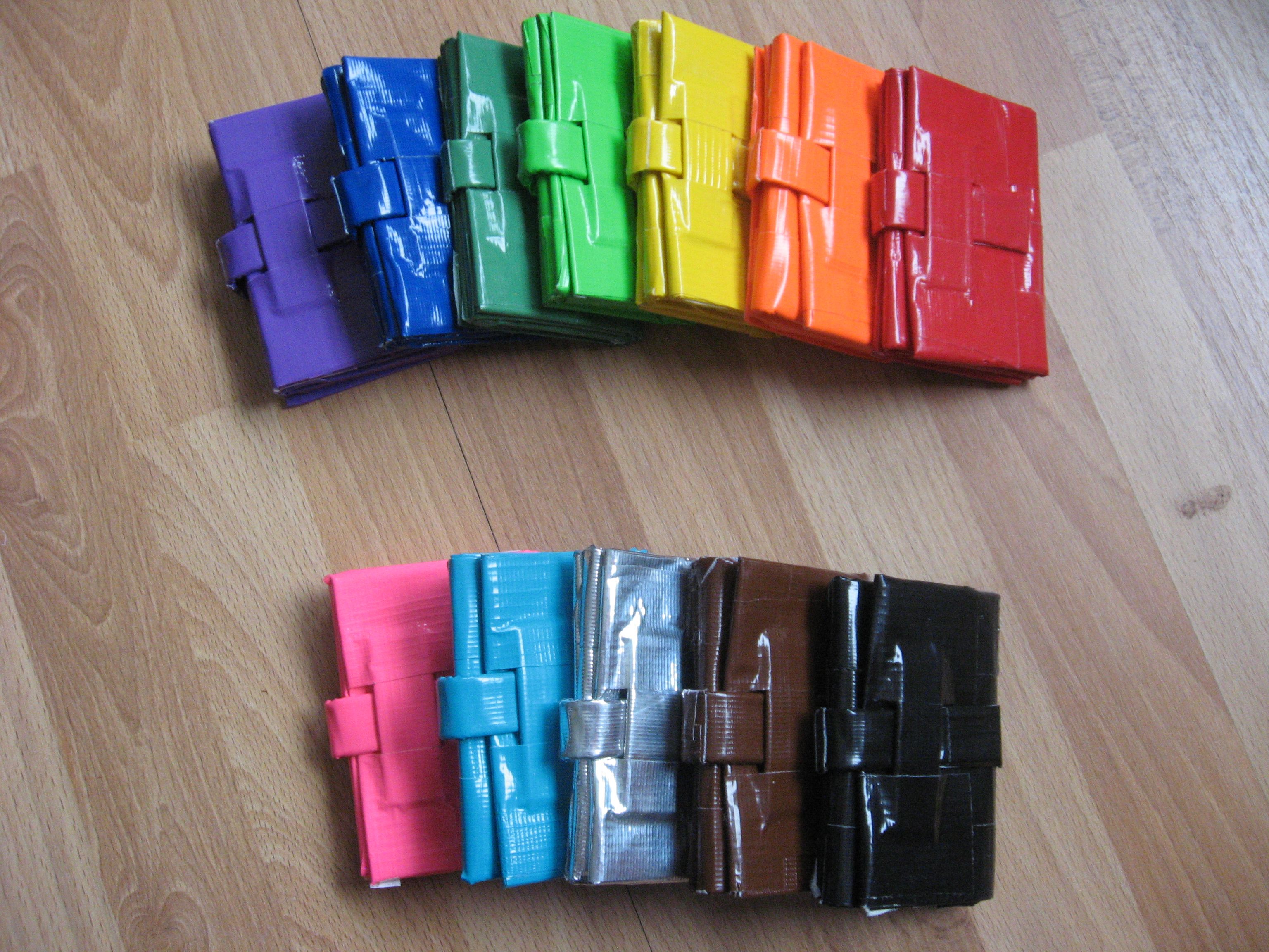12 duct tape wallets in two rows of various colors in reverse rainbow order