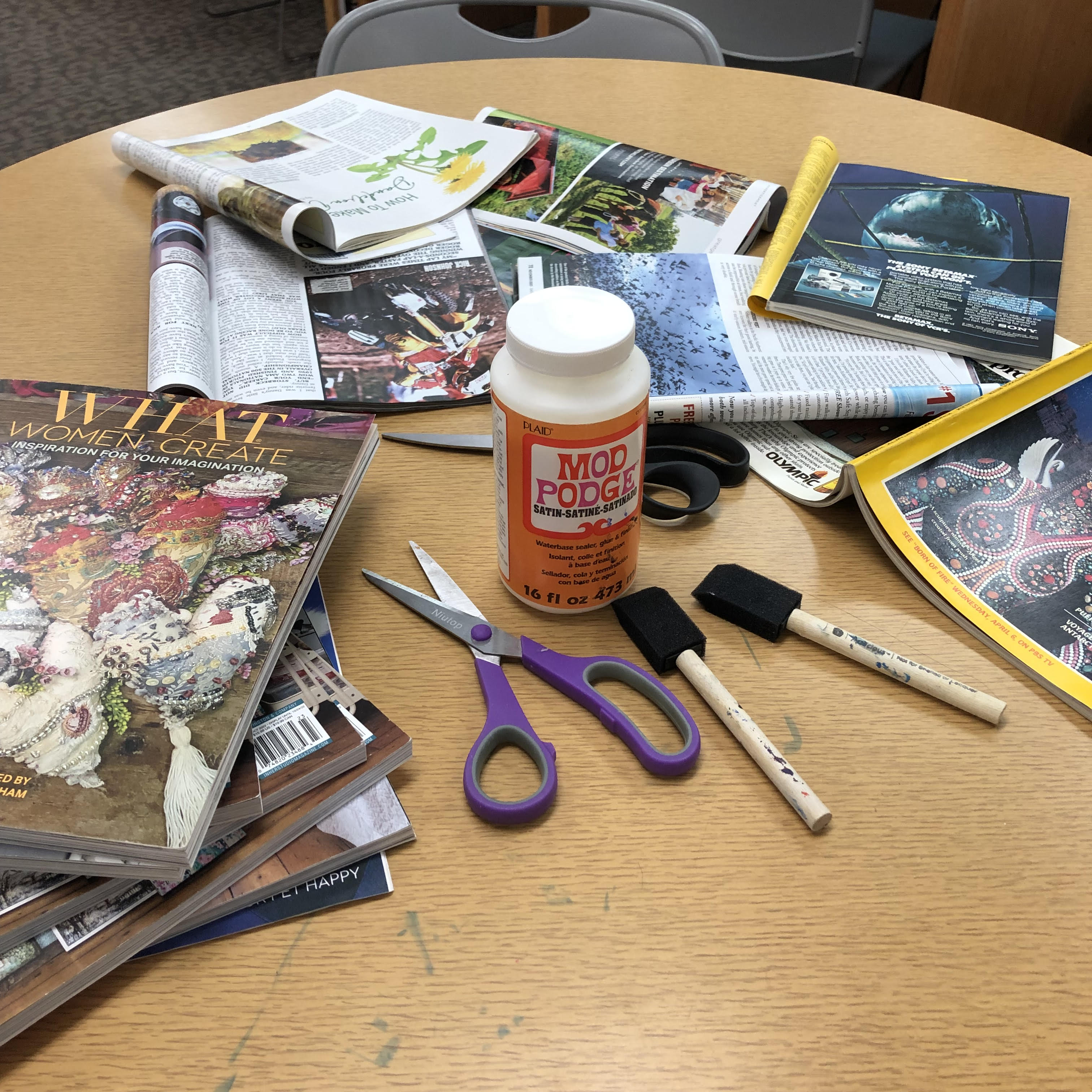 Scissors, Mod Podge, and magazines on a library table