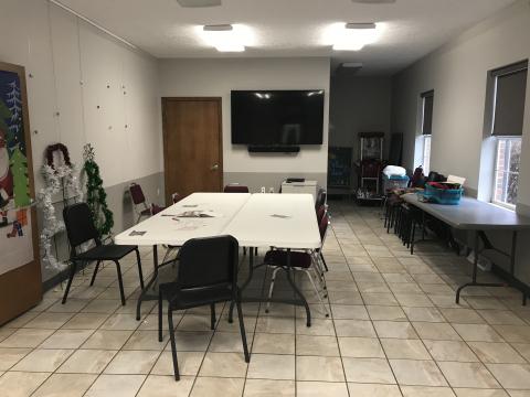 The meeting room at Coolville Public Library, including table, chairs, and mounted screen for presentations.