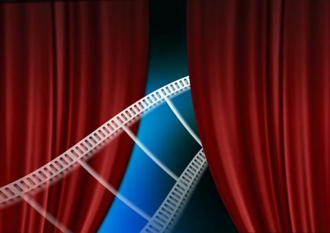A strip of film exits between two red curtains