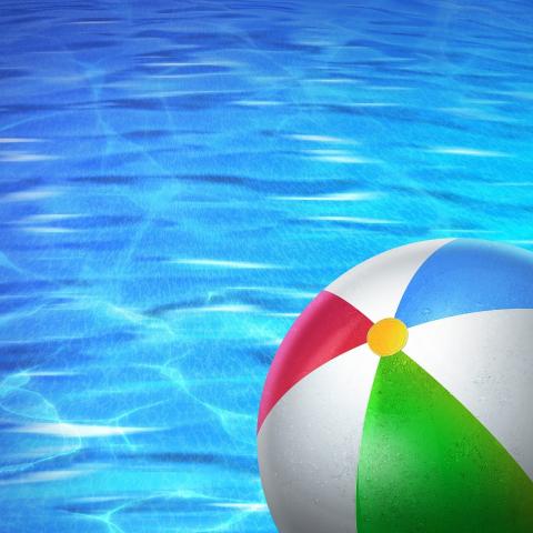 A colorful beach ball against a background of swimming pool water