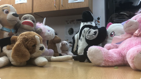 Several stuffed animals sit at the kids' table at Chauncey Library