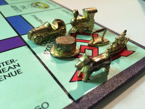 Classic Monopoly pieces on the "GO" space
