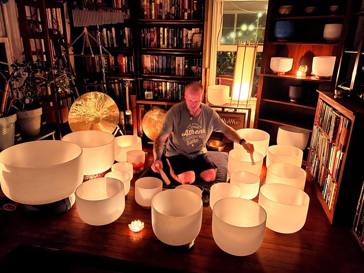 A picture of Kojun Hayes playing singing bowls.