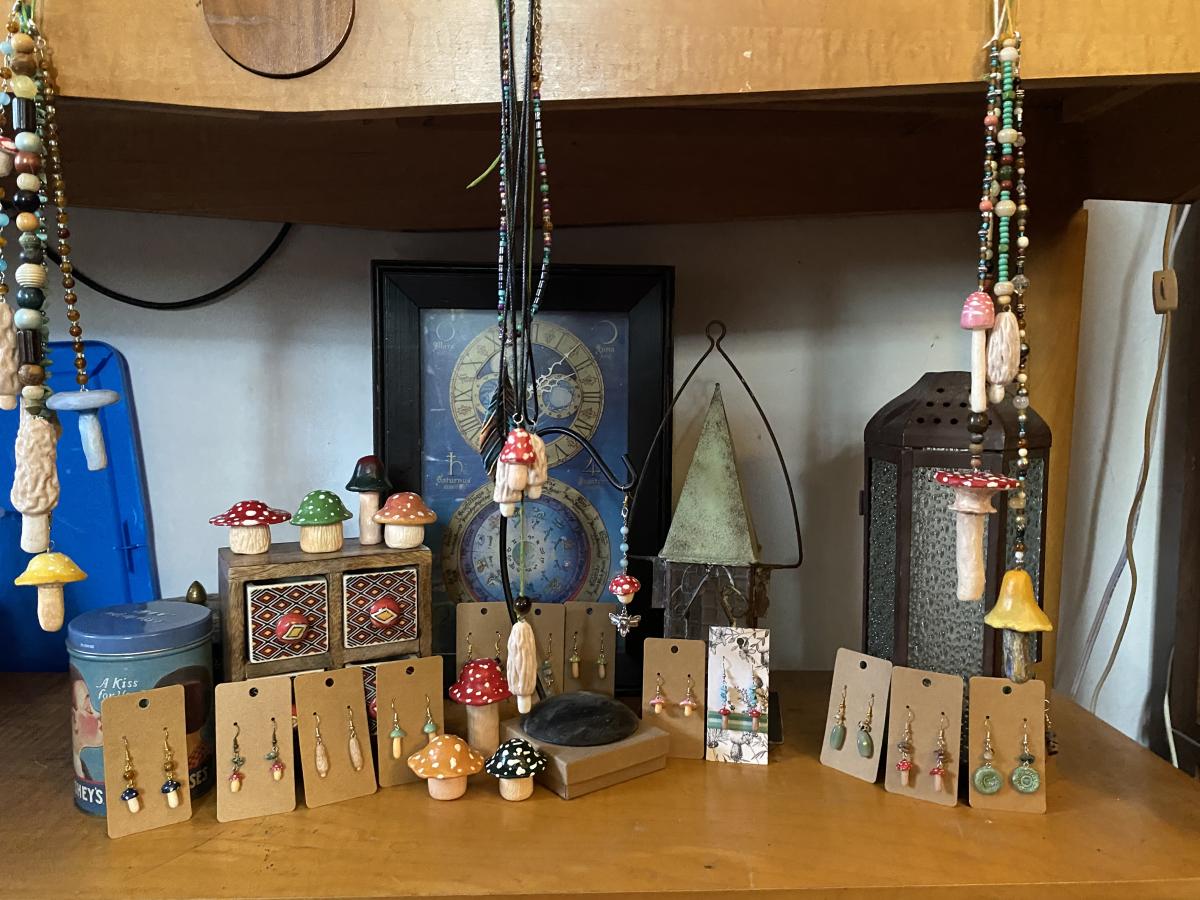 Mushroom necklaces and earrings hanging on display