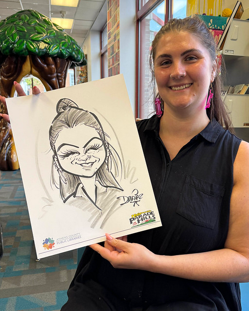Photo of Teen Librarian, Mel, and her caricature drawing from Parade of the Hills 2025