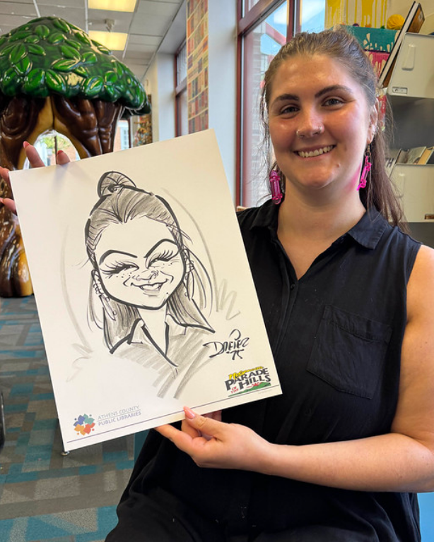 Nelsonville librarian Mel poses with a caricature drawing of herself